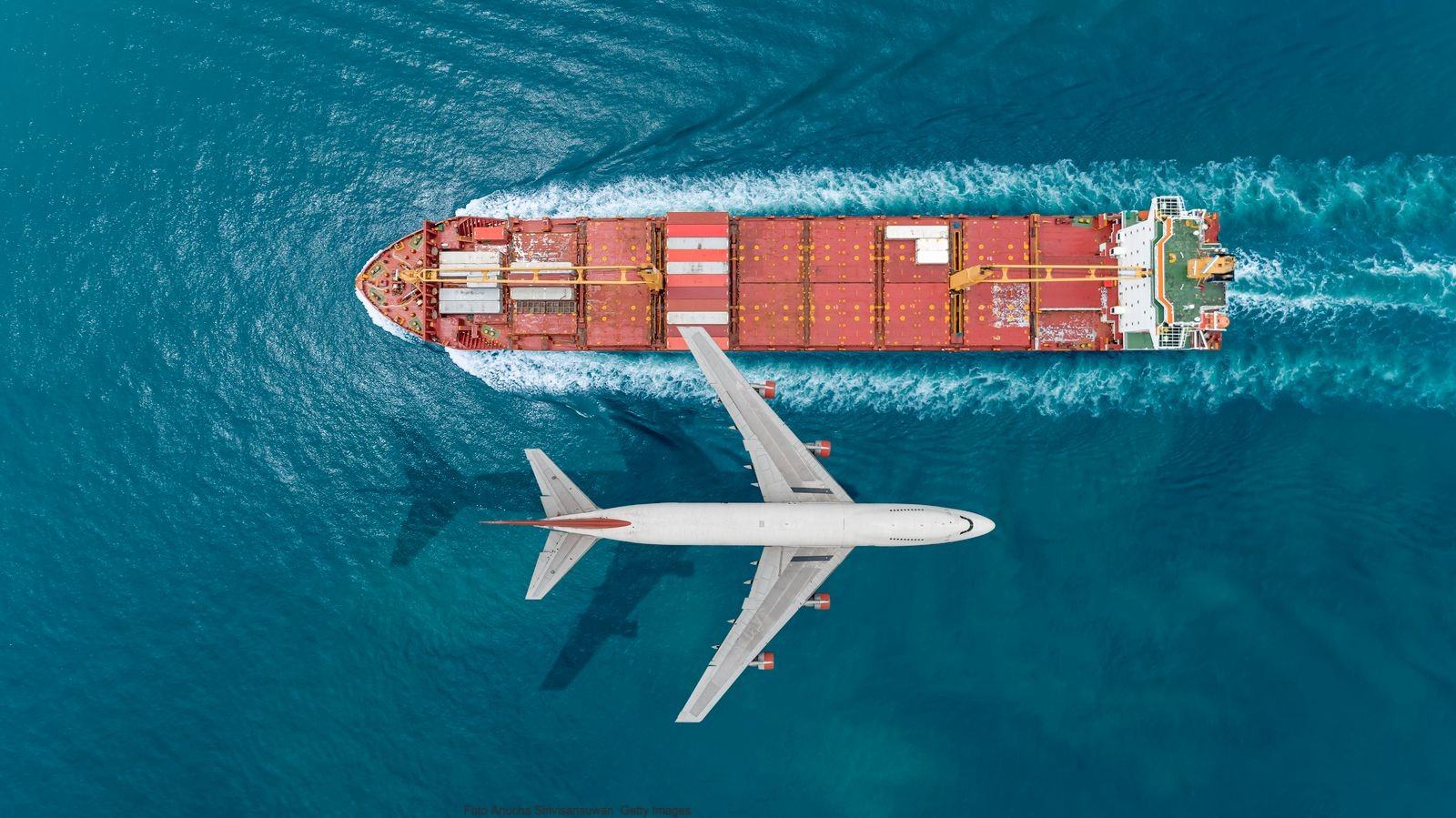 Luftaufnahme eines Flugzeugs über einem Frachtschiff